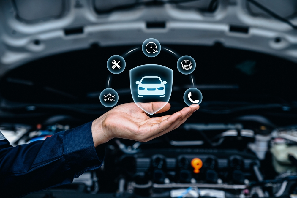 Vehicle maintenance icons above a hand in front of an open engine bay